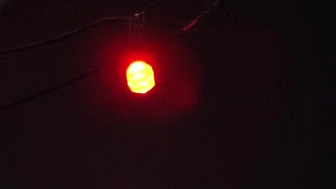 Small bulb on a black background is giving off red and blue light. 4K footage Video stock 290843109