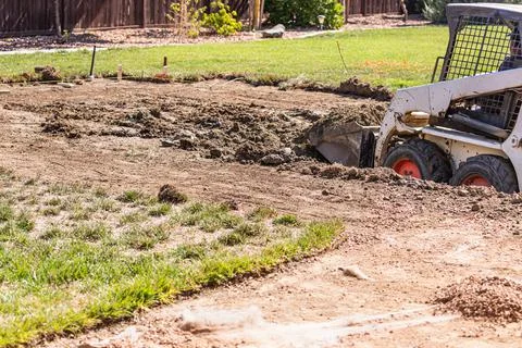 Small Bulldozer Digging In Yard For Pool Installation. Stock Photos