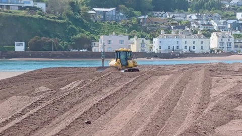 A small bulldozer pushing sand at The Point, Teignmouth, Devon, England. Stock Footage 335414876