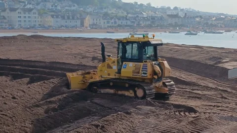 A small bulldozer pushing sand at The Point, Teignmouth, Devon, England. Stock Footage 335791529