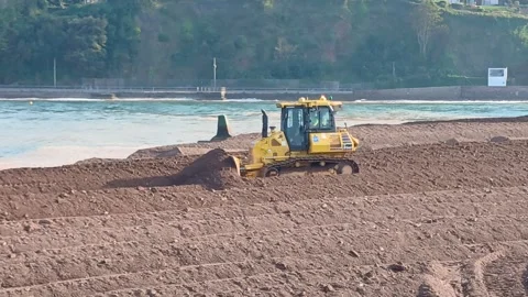 A small bulldozer pushing sand at The Point, Teignmouth, Devon, England. Stock Footage 335792255