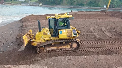 A small bulldozer pushing sand at The Point, Teignmouth, Devon, England. Stock Footage 337137584