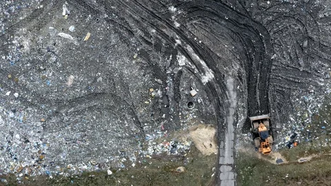 Small bulldozer on the solid waste dump, Pollution from waste Stock Footage 106693018