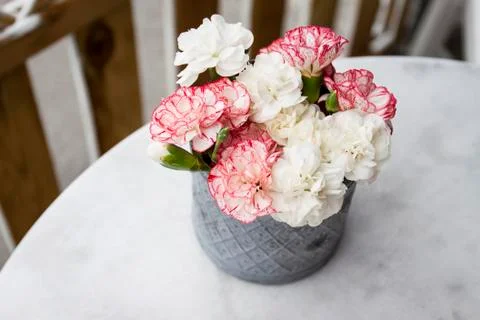 A small bunch of flowers in a vase on a table Stock Photos