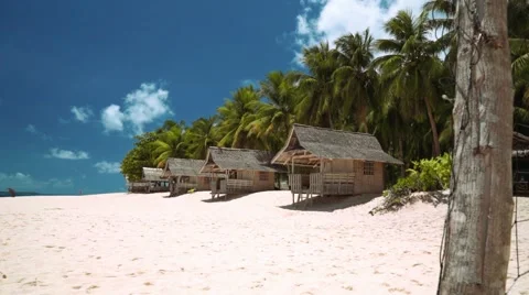 Small bungalows on white sand beach on tropical island, volleyball net Stock Footage 67412366