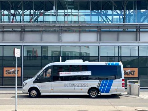 A small bus is parked at the rather lonely Stuttgart airport with a sign saying Stock Photos