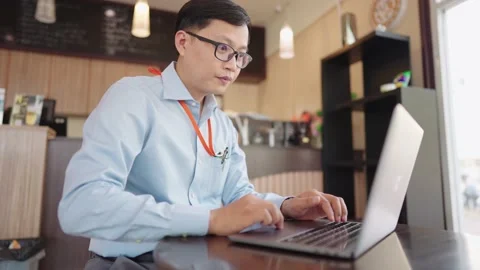 The small business manager is using a laptop to check stock. Vidéo 147956771