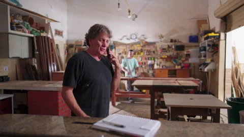 Small Business owner of Carpenter workshop speaking with customer on phone .. Stock Footage 247281545