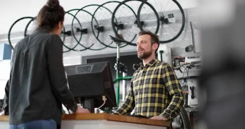 Small business owner serving customer in a bicycle store Stock Footage 87906600