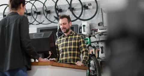 Small business owner serving customer in a bicycle store Stock Footage 87906973