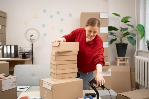 Small Business Owner Using Barcode Scanner to Check Product Inventory in Lo.. Stock Photos