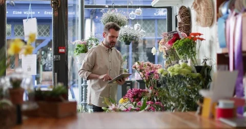 Small business owner using digital tablet in a florist Stock Footage 87932025
