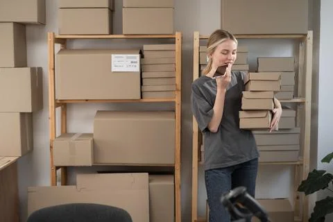 Small business owner using mobile app holding parcel box. entrepreneur sell.. Stock Photos