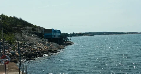 Small cabins overlooking the glittering sea 스톡 동영상 113948747
