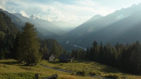 Small cabins sit on top of a valley at sunset Stock Footage 101900610