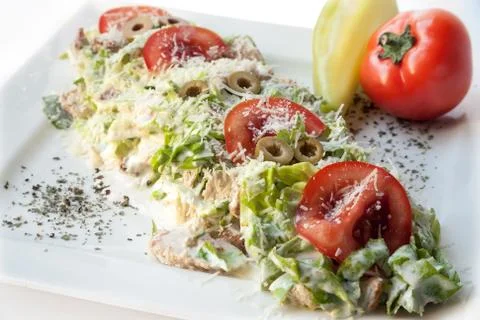 A small caesar salad with shredded parmesan cheese, croutons and tomatos Stock Photos