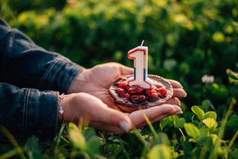 Small cake with a candle in the form of numbers 1 Stock Photos