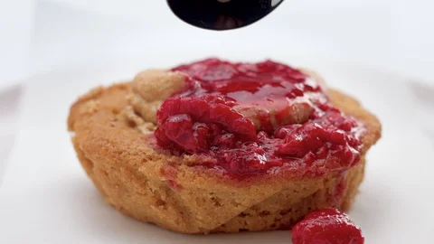 Small cake with fruit topping pouring on it Stock Footage 108312783