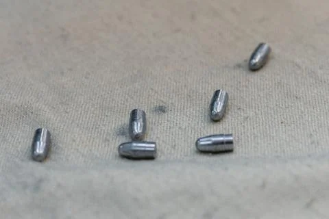 Small caliber bullets on rough fabric at production plant Stock Photos