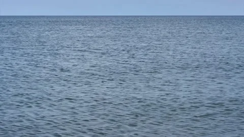 Small calm ocean waves with horizon and beautiful blue sky - water background Stock Footage 143524629