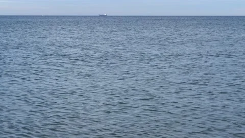 Small calm ocean waves with horizon and beautiful blue sky - water background Stock Footage 143524734