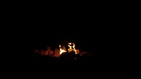 Small camp fire burning in ring of stones isolated in black Stock Footage 147239088