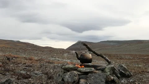 Small camp kettle is heated on a bonfire on a mountain Stock Footage 141644459
