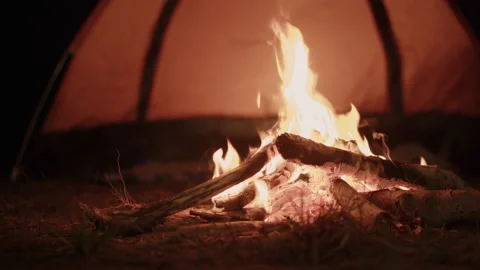 Small campfire with flames and camping on the beach in the summer at night Stock Footage 138725939