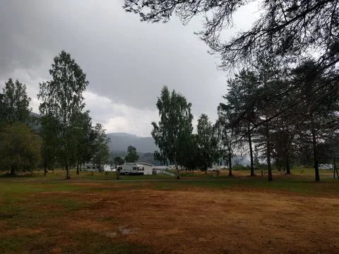 Small camping grounds with clouds and a lake in the background Stock Photos