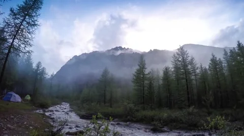 Small camping tent is pitched by a mountain stream in the woods in autumn with Stock Footage 65889092