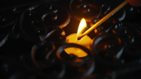 Small candle in a cast iron stand. Close-up of lighting a candle with a match Stock Footage 168313681