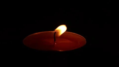 Small candle flame flutter on wind in darkness Stock Footage 318852248