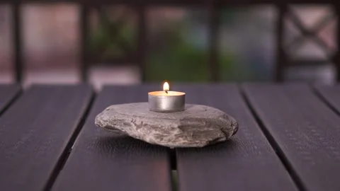 Small candle lit on the garden table Stock Footage 140813107