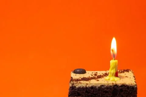 Small candle on a pie on a bright red background Foto stock