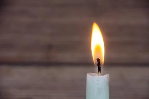 Small candle thumbnail with warm flame and blurred timber background creati.. Фото