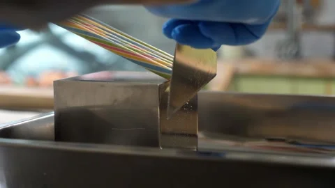 Small candy maker cuts a lollipop with a spatula. Handmade sweets. Stock Footage 258887971