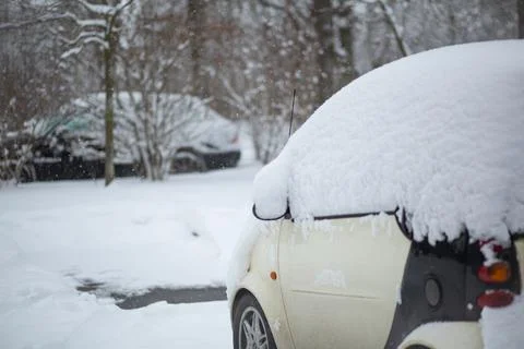Small car covered with snow in a winter day Stock Photos