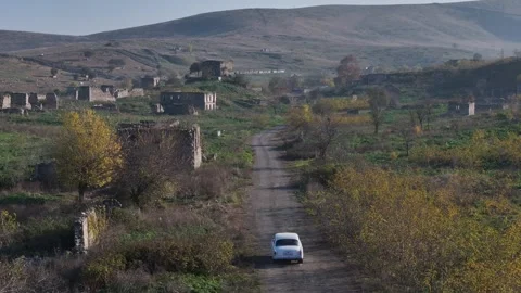 Small Car Drive Through Abandoned Village on a Rural Road in Autumn Stock Footage 341979823