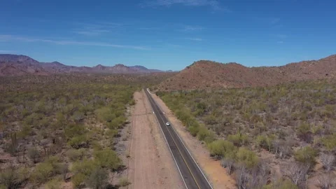 Small car driving along highway in Mexican desert area Видео 246733368