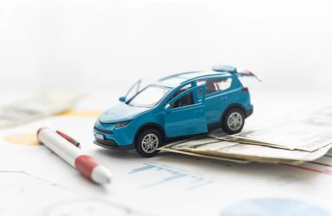 Small car model and blueprint sheets. Stock Photos