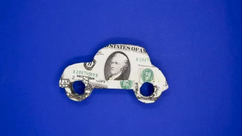 Small car model with dollar banknote on blue background Stock Footage 250436336