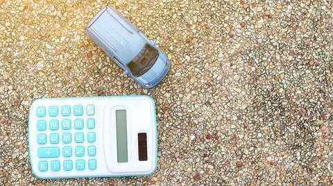 Small car model sits next to a calculator, symbolizing financial planning, .. Foto stock