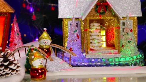 A small car pulls up next to the little house with the bridge and snowmen Video stock 346241570