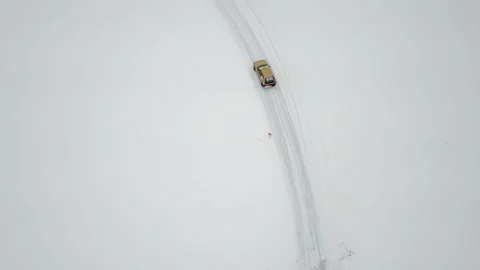 Small car rides by snowbound ice track, not far 库存影片 299634116
