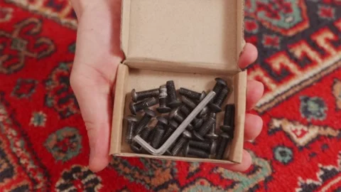 Small cardboard box with metal nuts and assembly hardware Stock Footage 346159495