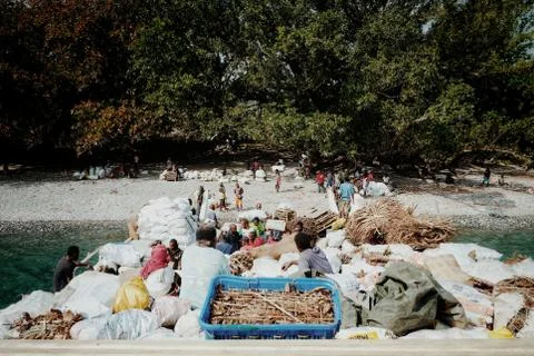 Small cargo boat offloading goods to a remote island while residents waiting  스톡 사진