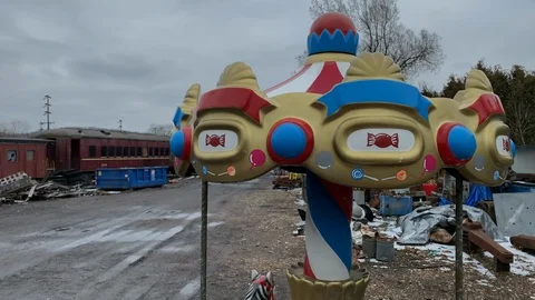 Small carousel in front of train junk yard Stock Footage 104000106