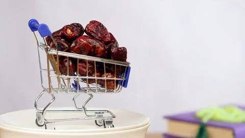 A small cart full of dry dates rich in iron rotating against a white background Stock Photos