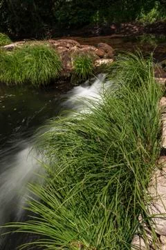 Small cascade in dam built of stone. Stock Photos