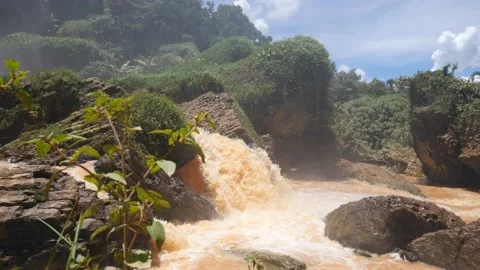 Small cascade flowing in the river jungle with huge rocks covered in greenery. Stock Footage 144084770